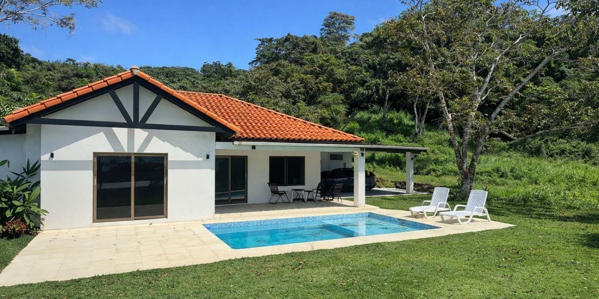 Yuma 44: single-storey home with terracotta roof and pool terrace, lawn and forest behind