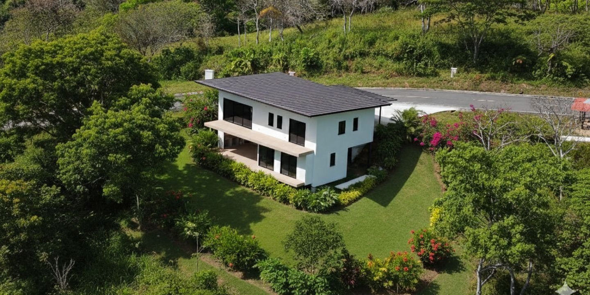 Aerial view of Yuma 54: two-storey home in a planted garden with the community road behind